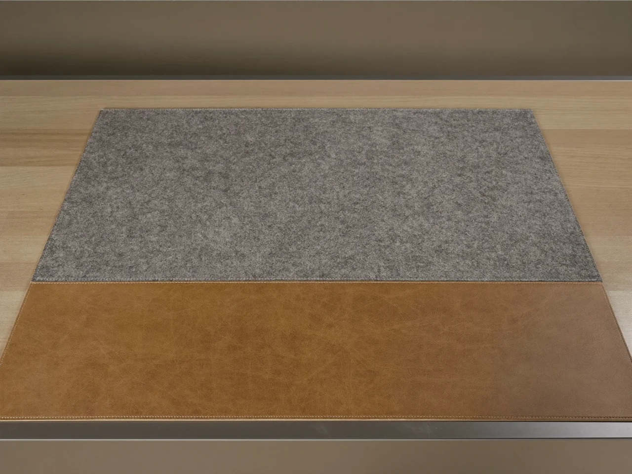 Breite Unterlage aus grauem Filz und Leder, flach auf einem hellen Holztisch ausgelegt.