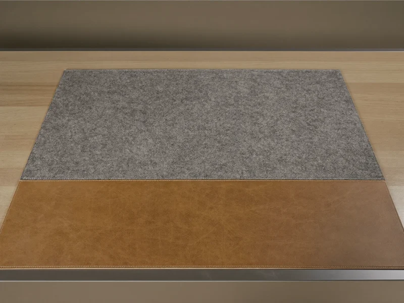 Breite Unterlage aus grauem Filz und Leder, flach auf einem hellen Holztisch ausgelegt.